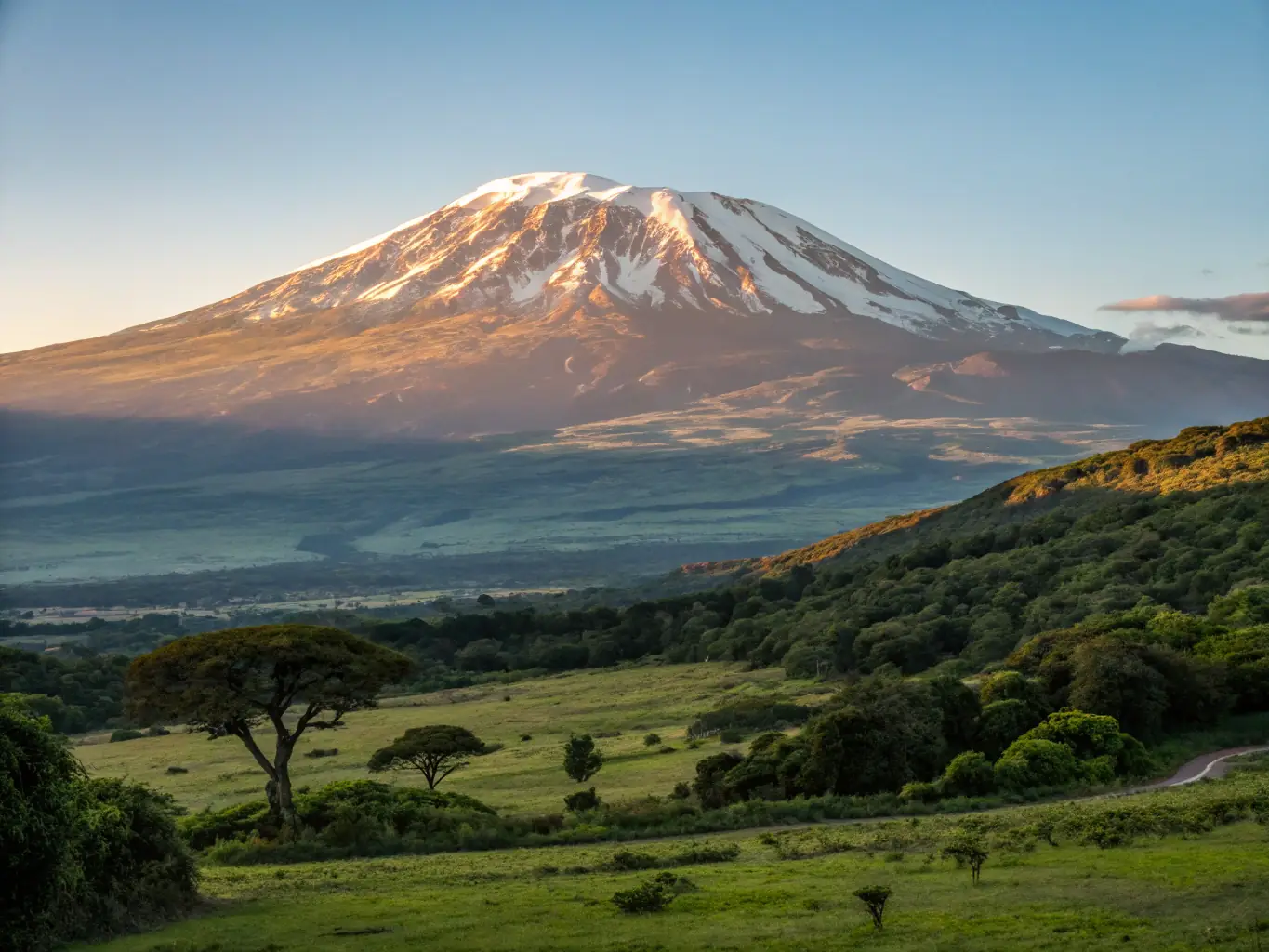 A serene photo of Mount Kilimanjaro in Tanzania, with a foreground of acacia trees and the vast African savanna.